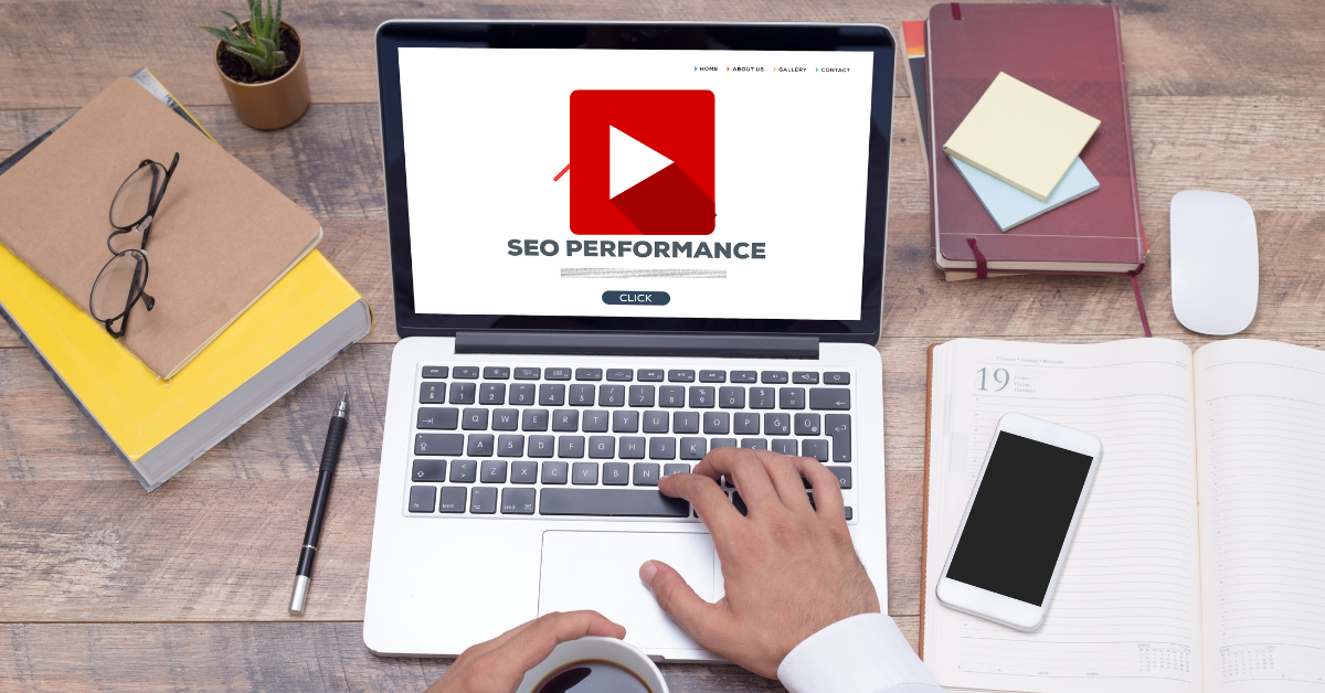 Laptop on a desk showing a play button and the words SEO performance
